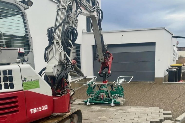 Minibagger mit Verlegezange beim Pflastern einer Hofeinfahrt