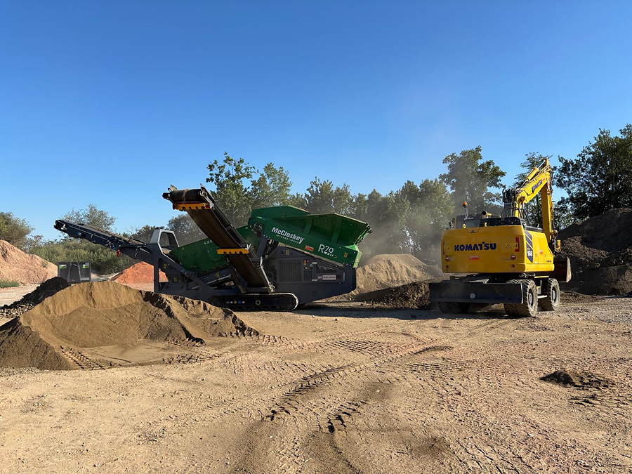 Siebanlage und Mobilbagger von der Seite, aufbereitete Haufwerke