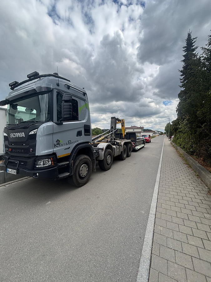 Scania-Vierachser mit Tieflader und Bagger auf der Anfahrt